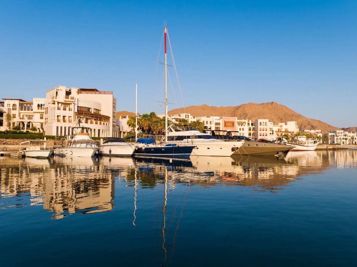 Jebel Sifah marina with yachts and mountains in the background